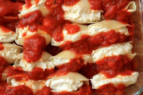 A pan of pasta shells, topepd with tomato sauce.